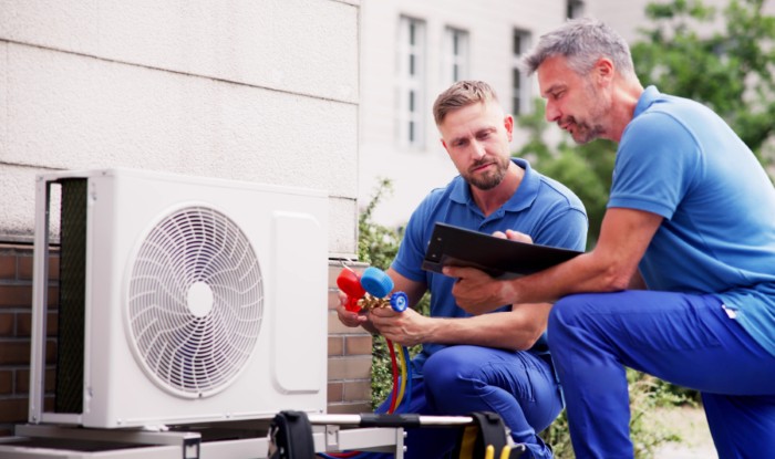 HVAC technicians reviewing an outdoor air conditioning unit in Kingman, AZ