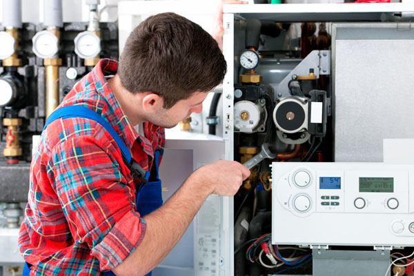 HVAC technician inspecting an indoor heating system in Kingman, AZ