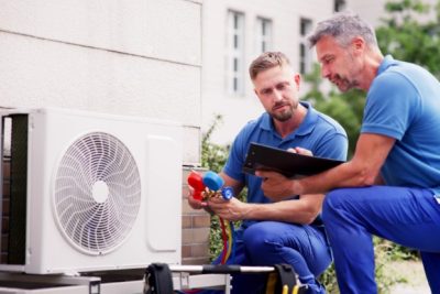 ac-installation-in-claremont-ca HVAC technicians reviewing an outdoor air conditioning unit in Kingman, AZ