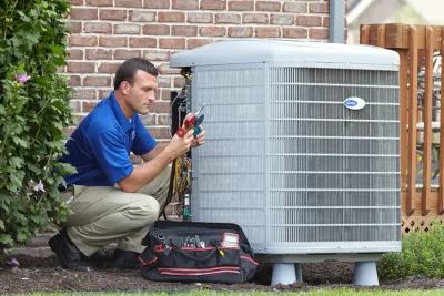 design-air-heating-and-air-conditioning-decatur-il-05 – Copy HVAC technician inspecting an outdoor air conditioning unit in Kingman, AZ