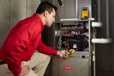 furnace repair Heating and air conditioning technician servicing an indoor furnace in Kingman, AZ